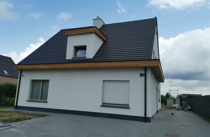 Isoleren van de buitengevel met crepi afwerking voor een moderne look. Dakgoten voorzien van een houten eiken constructie voor een elegante afwerking.