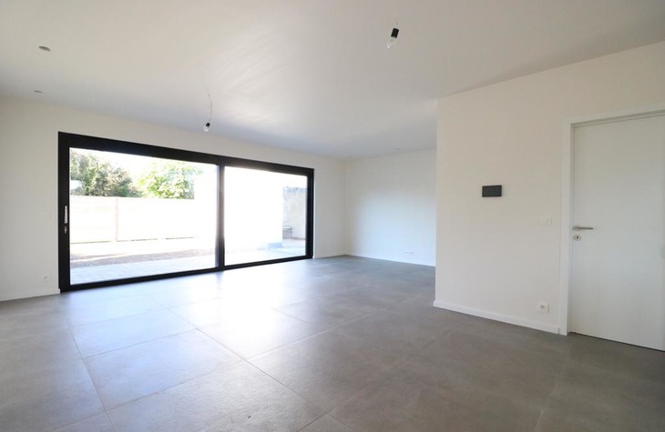 Aangename leefruimte met grote schuiframen en prachtige nieuwe tegelvloer