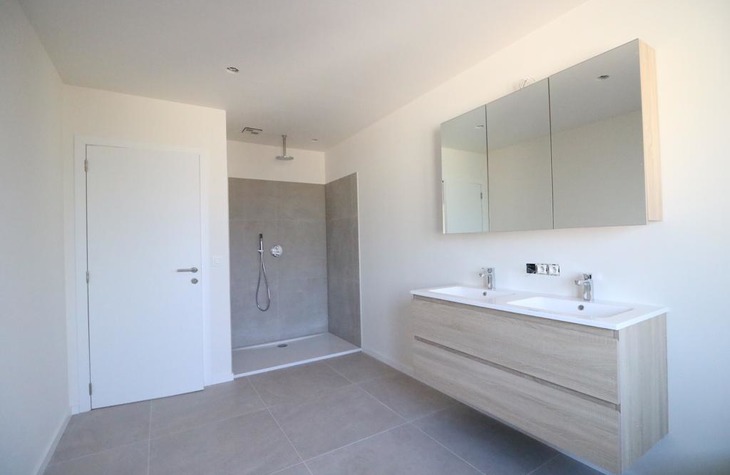 Moderne badkamer voorzien van een ruim wasmeubel en onderhoudsvriendelijke open inloopdouche